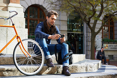 Buy stock photo Phone, city and bike with man on steps outdoor for communication, networking or social media. Travel, commute and zero emission bicycle with young person browsing internet on mobile in urban town