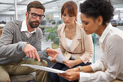 Buy stock photo Shot of a diverse group of young professionals discussing paperwork