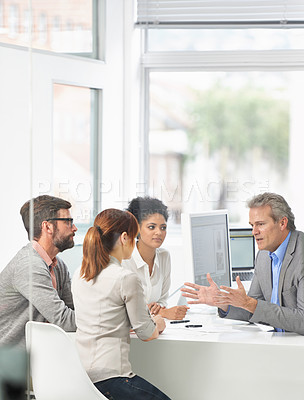 Buy stock photo A group of businesspeople going over some plans together