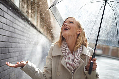 Buy stock photo Smile, excited woman and rain in the city with umbrella, freedom and happiness on holiday. Winter weather, raining or urban street with a young female person on a sidewalk and travel vacation outdoor