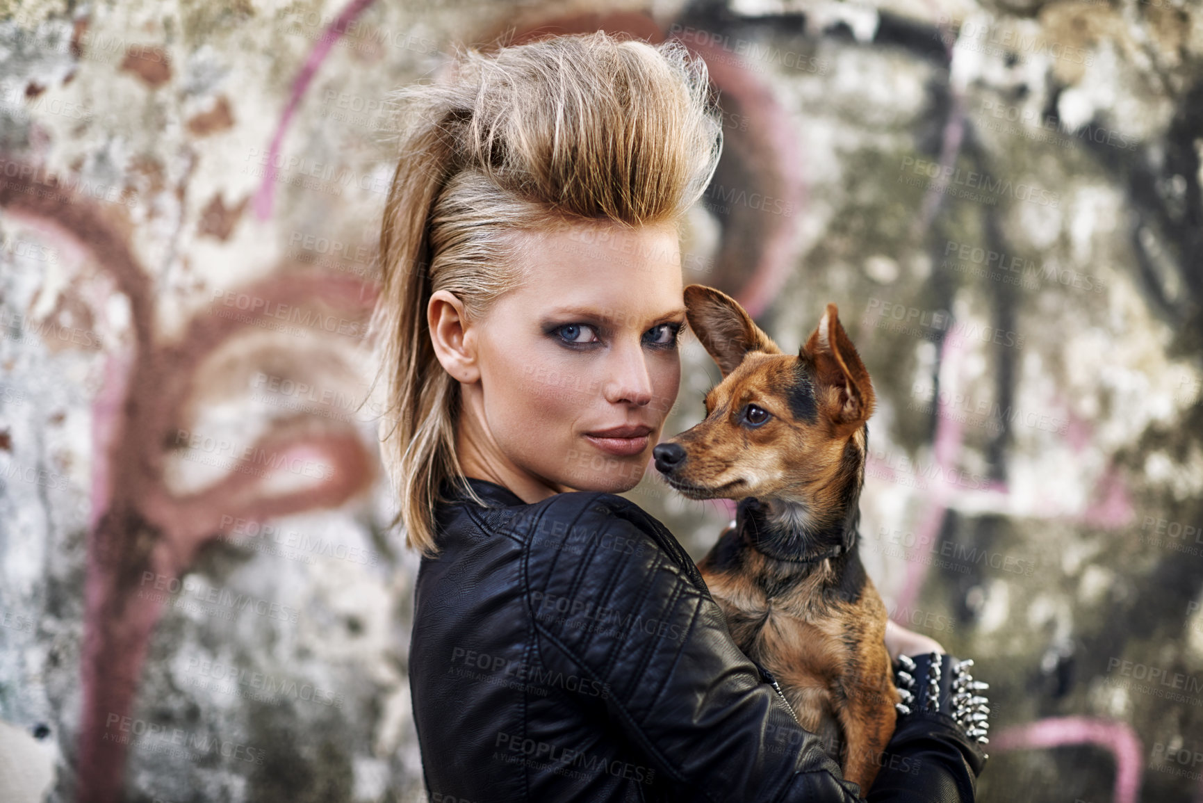 Buy stock photo A young trendy woman holding a small dog in an urban setting