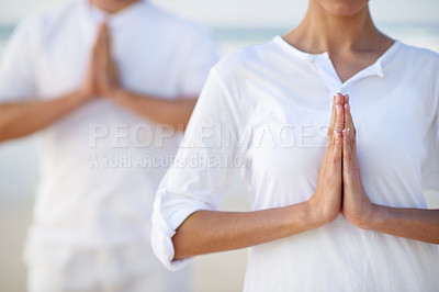 Buy stock photo Cropped shot of two people meditating on the beach