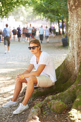 Buy stock photo Nature, sunglasses and man sitting by tree with confidence in an outdoor park on vacation. Travel, garden and male person thinking by wood trunk in field on holiday, adventure or weekend trip.