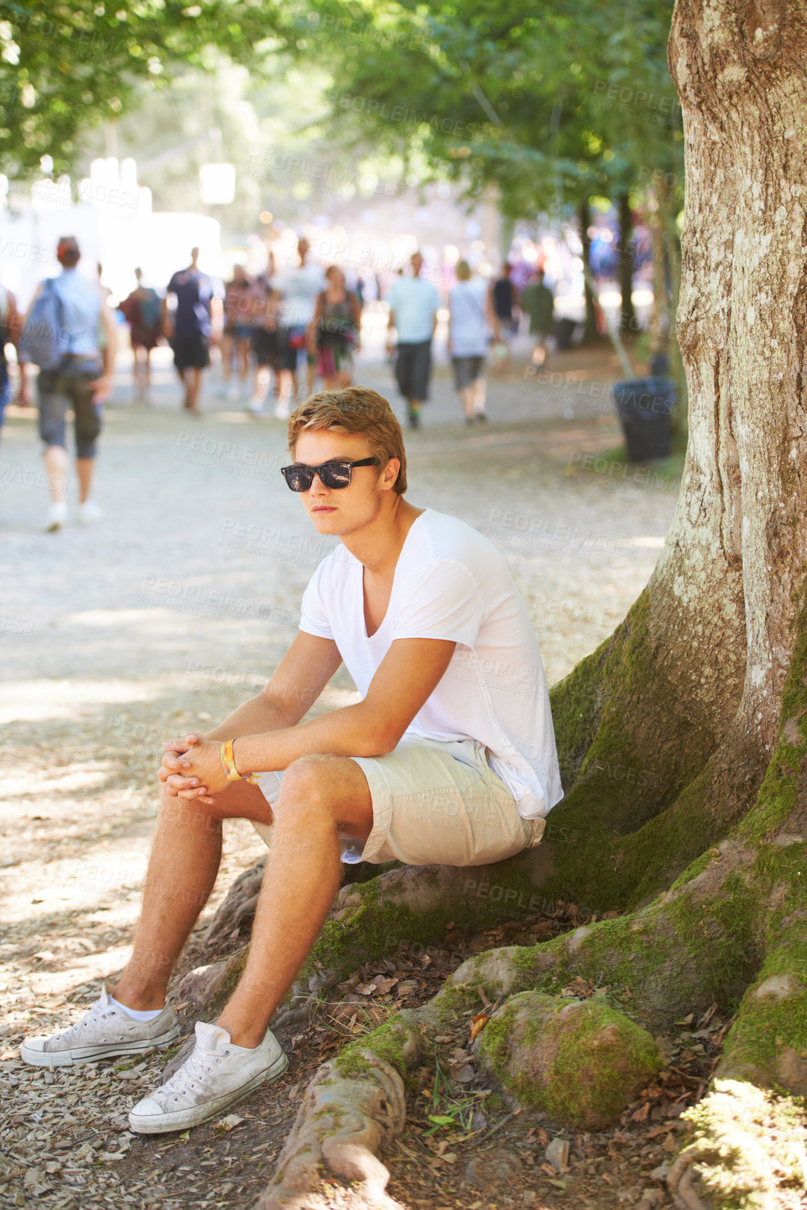 Buy stock photo Nature, sunglasses and man sitting by tree with confidence in an outdoor park on vacation. Travel, garden and male person thinking by wood trunk in field on holiday, adventure or weekend trip.