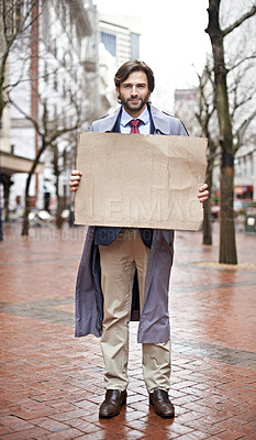 Buy stock photo Recession, business and man with cardboard, unemployed in city and professional with stress or poverty. Person, outdoor or financial criss with worker or stock market crash with job loss with mockup