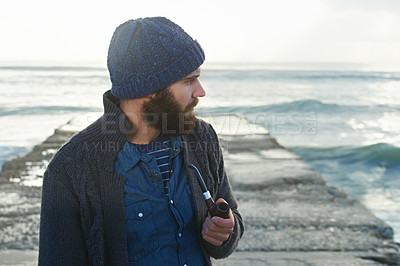 Buy stock photo Cropped shot of a bearded man smoking a pipe outside