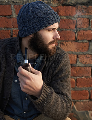 Buy stock photo Man, pipe and thinking by brick wall for planning, ideas or smoking in winter with beanie on head. Male person, fashion and tobacco for style, vision or contemplating outdoors on cold morning