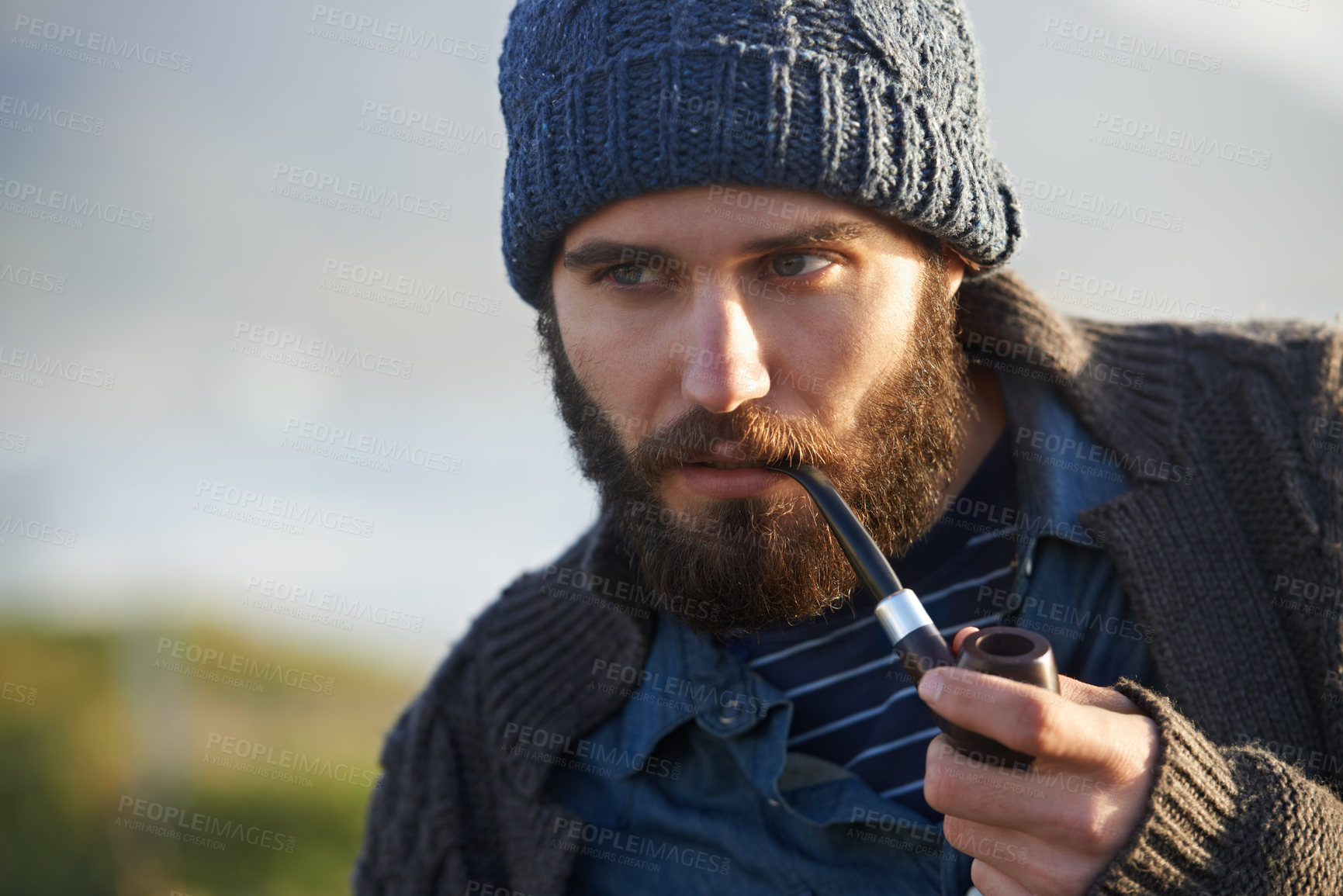 Buy stock photo Holiday, man and smoker with pipe in nature, lighter and tobacco habit on winter morning for sunrise. English guy, nicotine or vintage smoking for calm, satisfaction or vacation by ocean in cape town