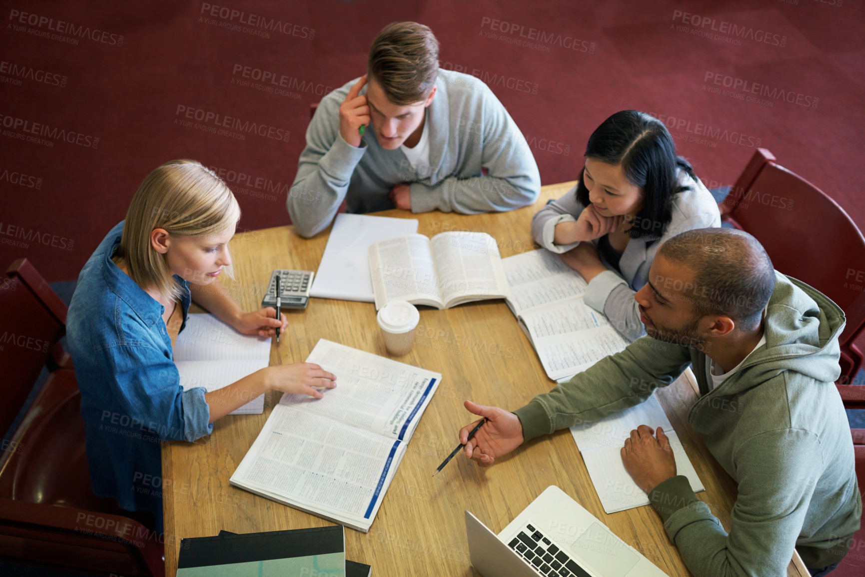Buy stock photo A group of young people studying together in the library