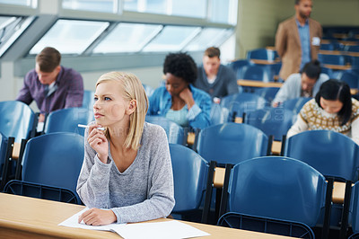 Buy stock photo Woman, student and exam in classroom with thinking for idea, knowledge and assessment at campus. Female person, planning and sitting with paper for brainstorming, education and growth in university