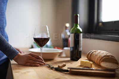 Buy stock photo Hand, red wine in glass and bread on table, dinner meal prep and drink to relax while cooking. Person at home, food and beverage to enjoy for nutrition, health and wellness with alcohol and supper