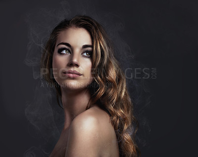Buy stock photo Studio concept shot of a beautiful young woman with smoke coming off her