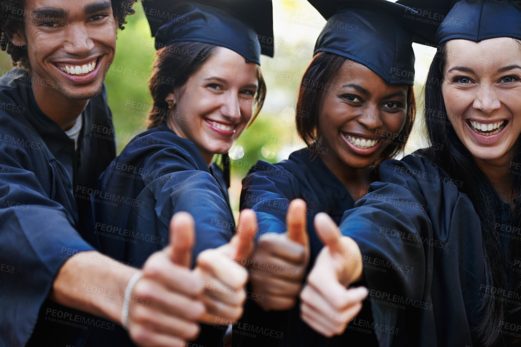 Buy stock photo A group of smiling college graduates giving the thumbs up at graduation