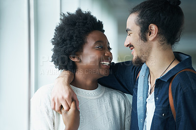 Buy stock photo A young couple standing together and sharing a smile
