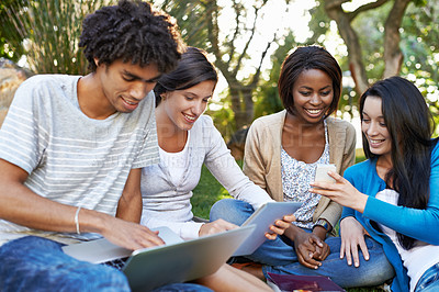 Buy stock photo Happy group, student and technology at park for collaboration, networking or communication. Young people or academic learners with smile on laptop, tablet and phone for online learning or education