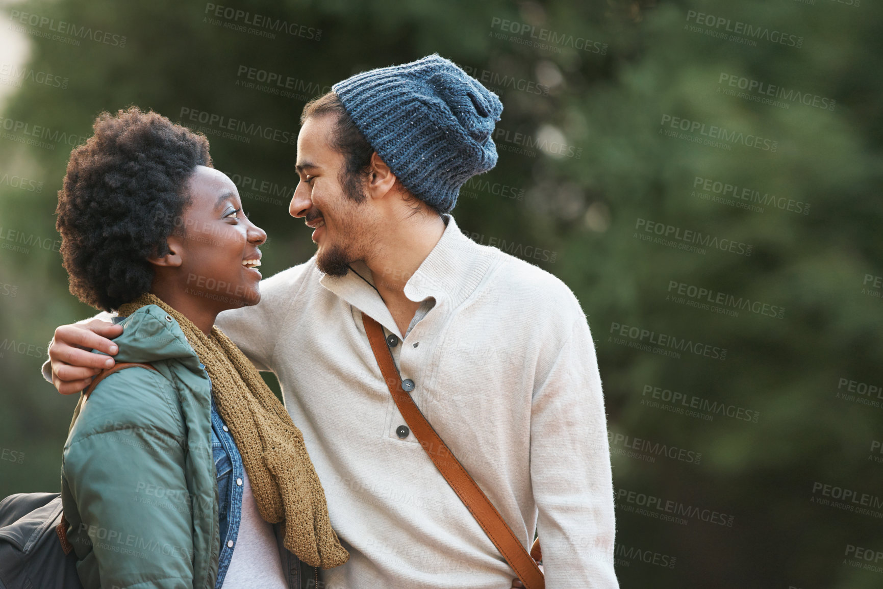 Buy stock photo Campus, park and happy interracial couple together with hug, bag and morning commute to university with love. College, students and romance in nature, man and woman with diversity, mockup and embrace