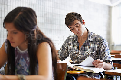 Buy stock photo Studying, students and reading in textbook for information, test and knowledge for assignment in university. People, scholarship or concentration in college by desk or academic research for learning