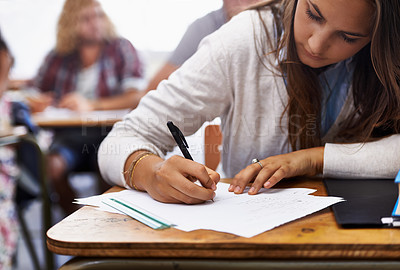 Buy stock photo University, classroom and woman writing exam at desk for education, knowledge and opportunity. College, learning and student with paper for test, assessment and studying with books, notes or report.