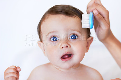 Buy stock photo Face, baby and hand brushing hair in home for grooming, care and cleaning on mockup space. Portrait, cute newborn and combing kid, healthy child or innocent infant with funny facial expression.
