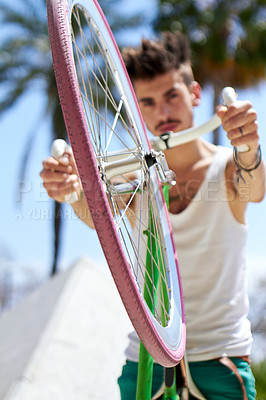 Buy stock photo Cropped portrait of a young man riding his bicycle