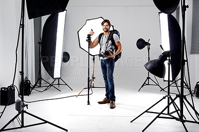 Buy stock photo Photographer, portrait and lighting with equipment in studio for career, behind the scenes or electronics. Photography, person or happy with cameras, flash and shooting gear for photoshoot or passion