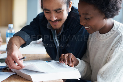 Buy stock photo A young college student helping a friend learn during a study group