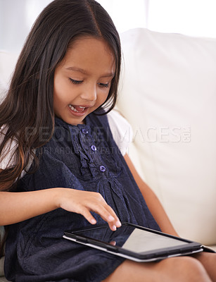 Buy stock photo Little girl, child and tablet on sofa for entertainment, movie or online streaming in living room at home. Face of female person or kid browsing or scrolling on technology for reading ebook at house