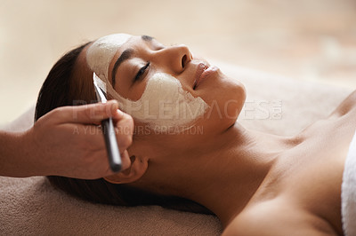 Buy stock photo A face mask being applied to a beautiful young woman at a beauty spa