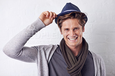Buy stock photo Smile, style and portrait of man by wall with casual, cool and trendy outfit for confidence. Happy, handsome and young male person with attractive fashion and hat standing by white brick background.