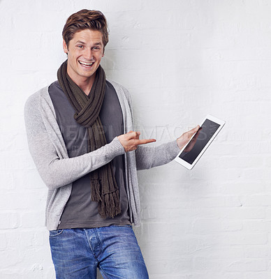 Buy stock photo Excited man, portrait and pointing to tablet screen for advertising or marketing on a white studio background. Happy and handsome male person with smile, showing technology display or mockup space