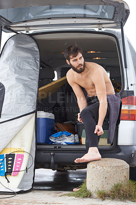 Buy stock photo Man, surfer and dressing by car for fitness, exercise or getting ready for waves or tide at beach. Male person or athlete with surfboard and wetsuit with clothing in outdoor preparation by vehicle