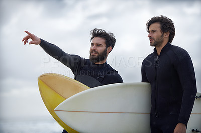 Buy stock photo Man, friends and surfer pointing on beach for fitness, sport or waves on shore in outdoor exercise. Young male person or people with surfboard for surfing challenge or hobby on ocean coast in nature