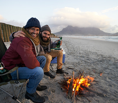 Buy stock photo Men, sunset and campfire with portrait, smile and happy from travel adventure and journey outdoor. Friends, ocean and sea with bonding, hug and vacation by the beach together on holiday with fire