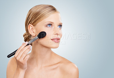 Buy stock photo Beauty, brush and face of woman in studio with confidence, natural makeup or facial glow. Glamour, cosmetics application and girl on blue background with healthy skin shine, mockup and wellness.