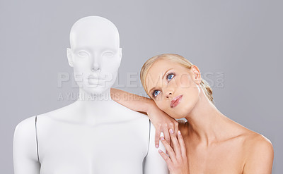 Buy stock photo Thinking, woman and mannequin with perfect beauty versus artificial standard, studio and facial wellness. Girl, doll and face in profile for cosmetics, plastic surgery or ideas on grey background.