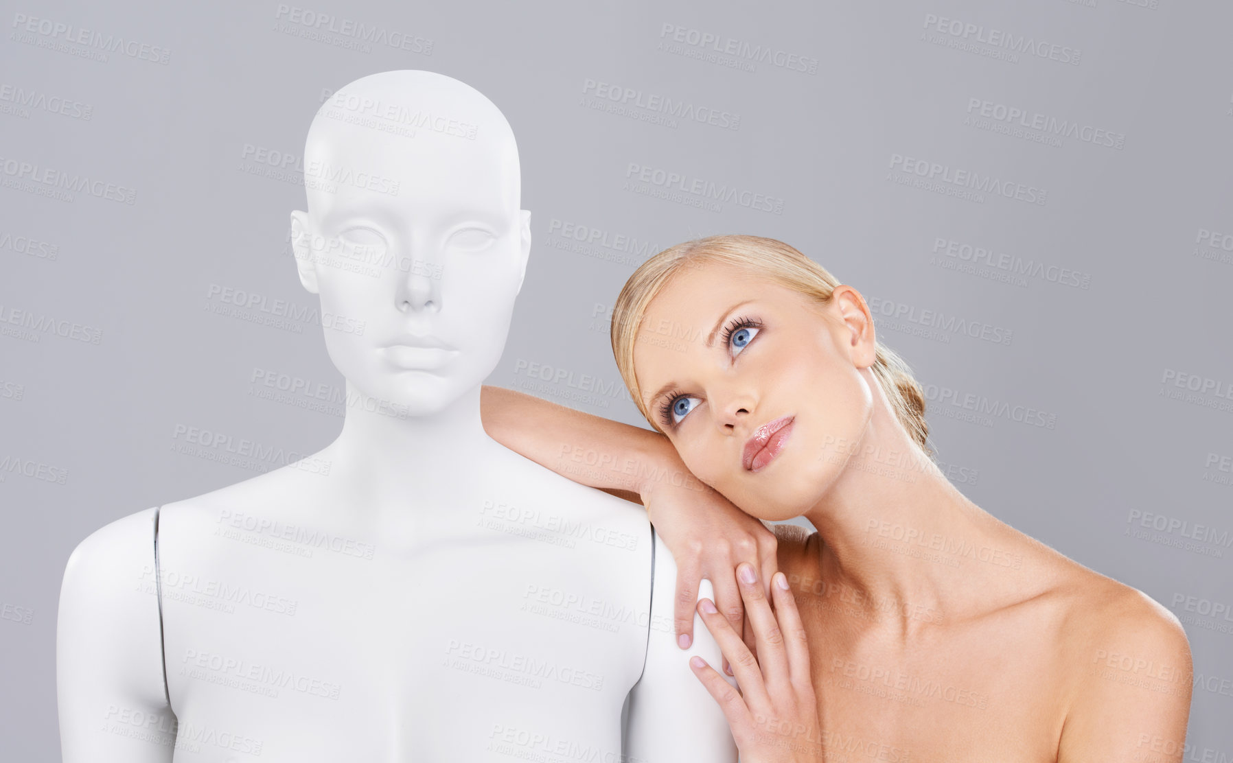 Buy stock photo Thinking, woman and mannequin with perfect beauty versus artificial standard, studio and facial wellness. Girl, doll and face in profile for cosmetics, plastic surgery or ideas on grey background.