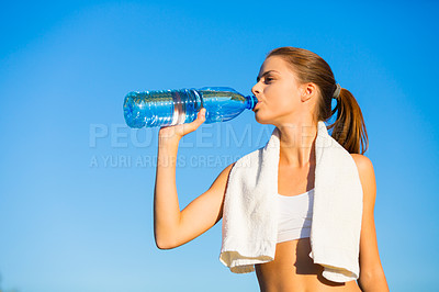 Buy stock photo Shot of a beautiful young woman drinking water after her workout