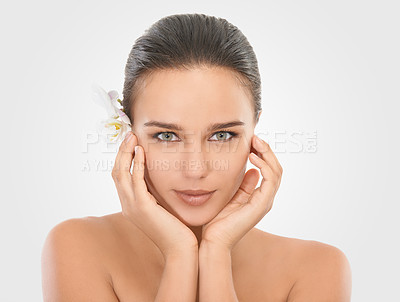 Buy stock photo Woman, portrait and orchid with glow for skincare in studio, beauty and natural makeup for blossom. Girl, plant and white background, closeup and hands on face with cosmetics dermatology for wellness