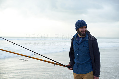 Buy stock photo Relax, fishing and man walking on beach with rods, nature and outdoor holiday adventure. Ocean, tools and fisherman with pole, smile and cloudy sky with waves on winter morning vacation at sea.