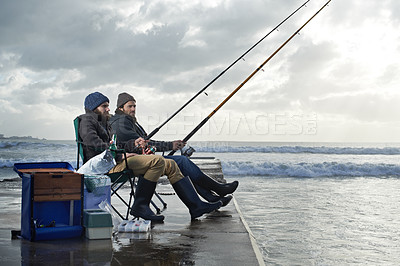 Buy stock photo Ocean, rod for fishing and men outdoor in winter, leisure activity at beach or harbor with friends in nature for seafood. Travel, seascape and waves with fisherman, recreation or hobby in the cold