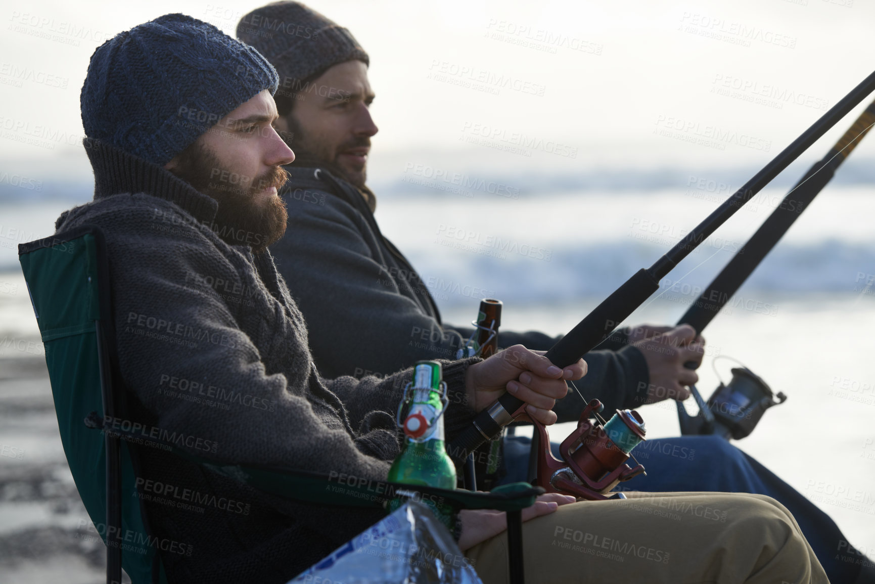 Buy stock photo Friends, men and fishing on beach in nature with rod, alcohol and relax on vacation, holiday or travel. Friendship, people and bonding in morning with overcast, sky and waves for activity or hobby