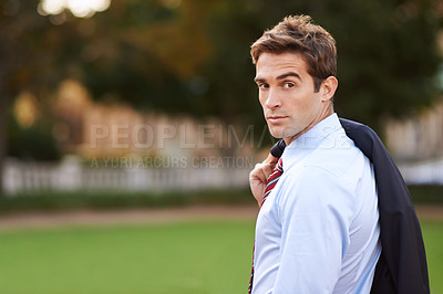 Buy stock photo Shot of a handsome and stylish businessman in a city park