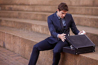 Buy stock photo Business, briefcase and man sitting on steps outside law firm in city, outdoor commute and sidewalk of court building. Businessman, lawyer or attorney on outdoor stairs checking bag for travel.