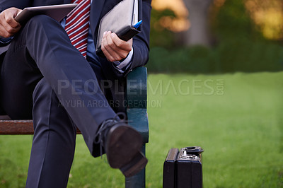 Buy stock photo Closeup, tablet and business man on bench, park and planning with lunch break and professional. Employee, outdoor and consultant with suitcase and technology for ideas and shoes with fashion or relax