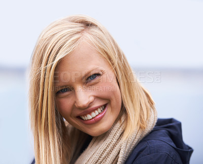 Buy stock photo A young woman standing by the ocean on a cloudy day - closeup