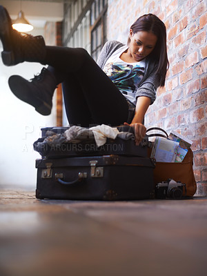 Buy stock photo A young woman trying in vain to close an over-full suitcase