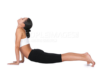 Buy stock photo A young woman doing yoga stretches while isolated on white