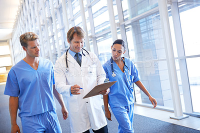 Buy stock photo A medical team walking in the hospital corridor