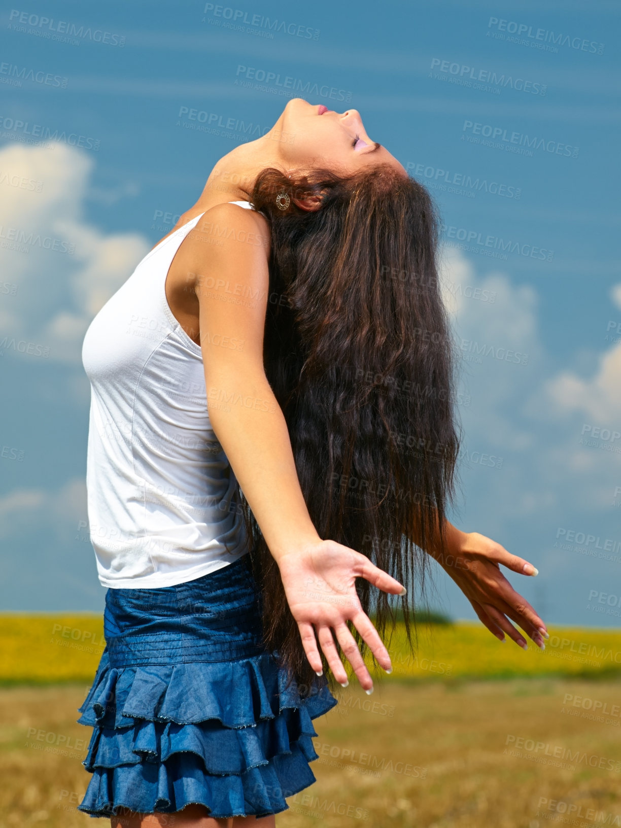 Buy stock photo Shot of a beautiful young woman standing in the countryside with her arms opened in joy