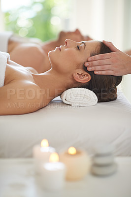 Buy stock photo A husband and wife lying together on massage tables and receiving head massages